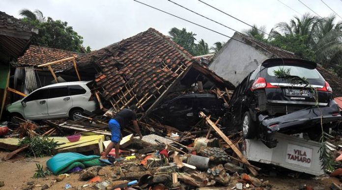A resident searches for items among the ruins of a villa after the area was hit by a tsunami, at Carita beach in Padeglang